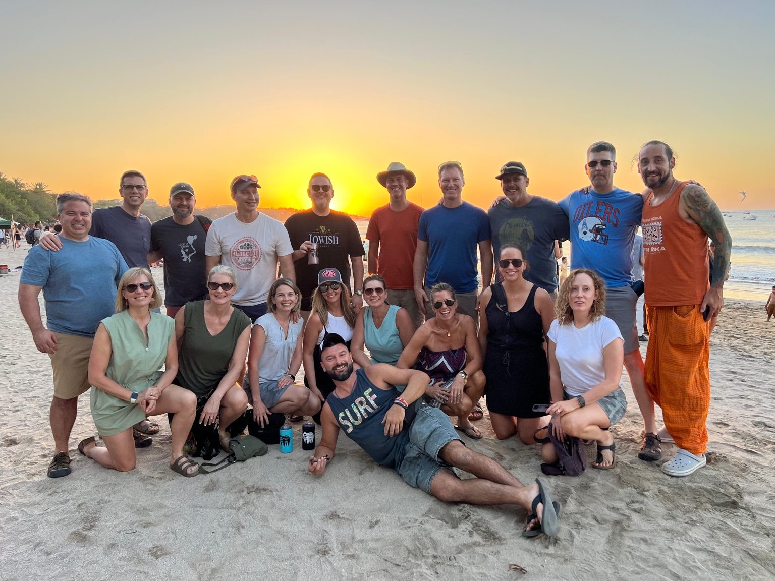 Family and friends together on a beach at sunset